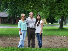 Ben and Janine Soulliere and their daughter Jolayne, 22, are shown Wednesday, June 4, 2014, at the city of Windsor park that connects to their backyard in east Windsor, Ont. The family is upset that the swings have been removed from the park located at Riverdale Ave. and Little River Rd. The couple's son Blaise, 20, who is autistic used the swing frequently. (DAN JANISSE/The Windsor Star)