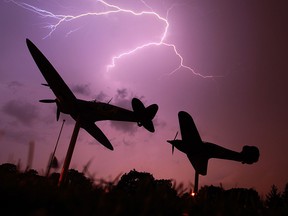 Lightning explodes across the sky as the Spitfire and Hurricane replica planes are silhouetted at Jackson Park in Windsor, Ont. in this 2011 file photo. (JASON KRYK/The Windsor Star)