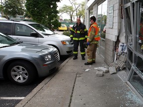 Windsor firefighters survey the scene Monday at 2301 Tecumseh Rd. E., after a full-sized Chrysler collided with the front entrance of a medical centre. An elderly driver was checked out by Essex-Windsor EMS paramedics and Windsor Police were called to investigate. Windsor firefighters used caution tape to close the front entrance. (NICK BRANCACCIO / The Windsor Star)