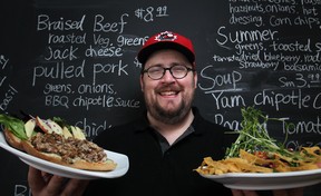 Mike Cowan, owner of The Carvery, displays a porchetta sandwich and a summer salad at his new restaurant at Wyandotte Street East and Hall Avenue. (DAX MELMER / The Windsor Star)