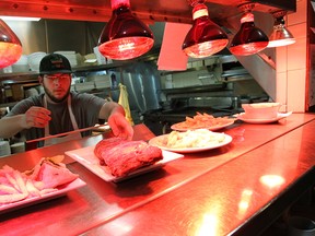 Tyler Seman serves up a plate of ribs at Tunnel Bar-B-Q in Windsor. (TYLER BROWNBRIDGE / The Windsor Star)