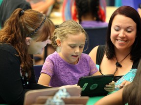 Mom Tara Steinhoff, left, and instructor Aimee Bellefleur, right, works with Tara's daughter Lizzie, during literacy segment of Summer Learning Program at the Catholic School Board offices Thursday July 10, 2014. (NICK BRANCACCIO/The Windsor Star)