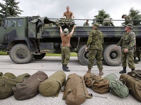 Military reserves arrive at Southport, Man. Saturday, July 5, 2014 to assist with flood preparation from Portage La Prairie to St Francois Xavier. THE CANADIAN PRESS/John Woods