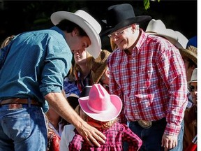 Prime Minister Stephen Harper, right, meets Liberal leader Justin Trudeau, left, and his daughter Ella-Grace at the Calgary Stampede parade, Friday, July 4. Trudeau's six-year-old son, Xavier, shook hands with the PM.
Photograph by: THE CANADIAN PRESS/Jeff McIntosh , Postmedia News