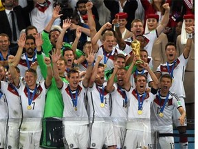 Germany's defender and captain Philipp Lahm (front-2R) holds up the World Cup trophy as he celebrates with his teammates after winning the 2014 FIFA World Cup final football match between Germany and Argentina 1-0 following extra-time at the Maracana Stadium in Rio de Janeiro, Brazil, on July 13, 2014. AFP PHOTO / PEDRO UGARTEPEDRO UGARTE/AFP/Getty Images