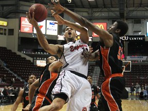 Windsor's Kevin Loiselle, centre, drives to the basket against Oshawa's Shamus Ferguson at the WFCU Centre. (DAX MELMER/The Windsor Star)