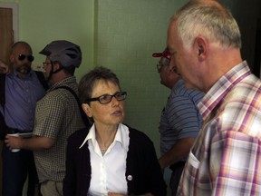 Windsor University Faculty Association president Anne Forrest, centre, speaks with physics professor Walter Kedzierski, right, following a special meeting to discuss the latest letter from University of Windsor president Alan Wildeman Friday July 4, 2014. (NICK BRANCACCIO/The Windsor Star)