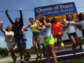 Queen of Peace Catholic School students Alyssa MacMillian, left, Dante Butera, behind, Lauren Ingratta, Ashlin Mastronardi, Paz Fizer, Angelica Tannous, Celina Read, Dea DiCiocco and Bryanna Rodrigues, right,  jump for joy after being told they can each collect up to $40,000 in scholarships if they attend Cardinal Carter and then post-secondary education June 30, 2014. (NICK BRANCACCIO/The Windsor Star)