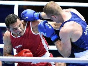 England's Warren Baister, right, lands a punch on Windsor's Samir El-Mais during a heavyweight (91 kg) quarter-final boxing match at the 2014 Commonwealth Games in Glasgow. (AFP PHOTO)