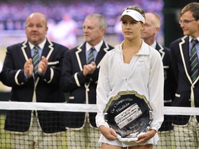 Runner up Canada's Eugenie Bouchard holds her trophy after losing to Czech Republic's Petra Kvitova the women's singles final match on day twelve of  the 2014 Wimbledon Championships at The All England Tennis Club in Wimbledon, southwest London, on July 5, 2014. (AFP PHOTO / GLYN KIRK)