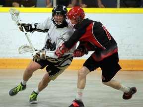 Windsor's Jarred Riley, left, is checked by a Wallaceburg player during playoff lacrosse action at Forest Glade Arena Tuesday. (JASON KRYK/The Windsor Star)