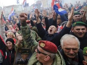 In this file photo, war veterans celebrate during the live broadcast from the International War Crimes Tribunal, on Zagreb's main square, Friday, Nov. 16, 2012. Appeals judges at the Yugoslav war crimes tribunal have overturned the convictions of two Croat generals  Ante Gotovina and Mladen Markac for crimes against humanity and war crimes committed against Serb civilians in a 1995 military blitz. Gotovina and Markac, were sentenced to 24 and 18 years respectively in 2011 for crimes, including murder and deportation. Judges ruled both men were part of a criminal conspiracy led by former Croat President Franjo Tudjman to expel Serbs. (AP Photo/Nikola Solic)