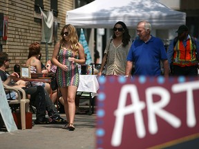 People browse past stalls of art work at the Alley Art Show and Sale in Maiden Lane, Sunday, July 20, 2014.   (DAX MELMER/The Windsor Star)