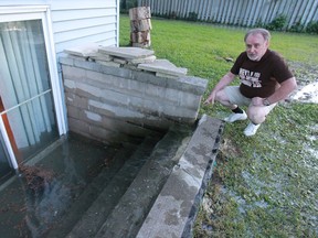 Bruce Sinclair looks at a steady stream of water flowing from a  broken water main into his home on Arthur Road in Windsor. There have been multiple water main breaks and Sinclair is very upset.  (JASON KRYK/The Windsor Star)