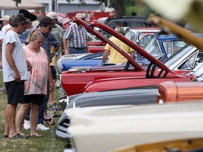 Attendees check out the engines of classic cars at Amherstburg's Gone Car Crazy Show 'n' Shine, Sunday, July 27, 2014.  (DAX MELMER/The Windsor Star)