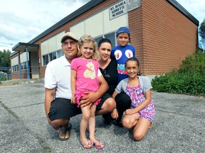 Mike and Jackie Malott and their children Jada, 10, Owen, 6, and Sara, 4, pose in front of the St Maria Goretti Catholic School in Windsor, Ont. on Wednesday, July 2, 2014. They are concerned with the board changing rules to allow non-catholics to attend catholic schools. (DAN JANISSE/The Windsor Star)