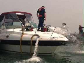 Crews from the U.S. Coast Guard work to empty out water from a 33-foot boat near MIddle Bass Island on Lake Erie on Sunday, July 20, 2014. (Courtesy of Petty Officer First Class Phillip Null/U.S. Coast Guard)