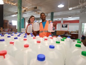 Demeeko Williams, Co-ordinator of the Detroit Water Brigade and volunteer Stephanie Howells sort through jugs of drinking water that will be distributed to those in need in Detroit, Michigan on July 9, 2014. (JASON KRYK/The Windsor Star)
