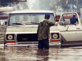 Marc Praill stops traffic going by his home in Harrow in an effort to prevent additional water damage.  (Windsor Star files)