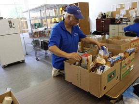 Despite almost empty shelves volunteer Ed Annett continues to load boxes of food for the needy at the Devine Mercy Food Bank in Windsor on Thursday, July 17, 2014. After 10 years of operation the food bank is closing.          (Tyler Brownbridge/The Windsor Star)