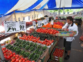 Justin Elias arranges vegetables at Louie's Produce Market on Manning Rd. in Tecumseh, Ont. on Wednesday, July 16, 2014. The Ontario Provincial Police is seeking the public's assistance to find the individuals that have vandalized the stand on several occasions.   (DAN JANISSE/The Windsor Star)