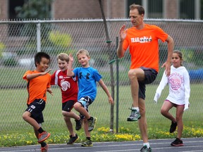 The Hospice for Kids Triathlon camp was held Wednesday, July 23, 2014, at the Lacasse Park in Tecumseh, Ont. Camp coach John Trojansek works with a group of youngsters on the track. (DAN JANISSE/The Windsor Star)