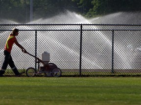 A park employee paints the lines the outfield on the softballs diamonds in Mic Mac Park in Windsor in this 2012 file photo. (TYLER BROWNBRIDGE /  The Windsor Star)