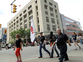 WINDSOR, ON.: JULY 18, 2014 -- Protesters march in front of the Paul Martin Building in Windsor on Friday, July 18, 2014. The group was protesting against the federal government for letting the building get in such bad shape. (Tyler Brownbridge/The Windsor Star)