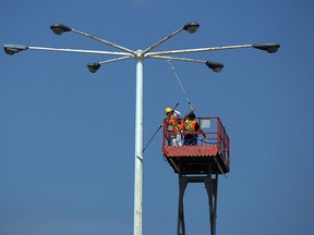 A pair of painters puts a fresh coat of paint on the light poles at the Devonshire Mall in Windsor on Monday, July 14, 2014.         (Tyler Brownbridge/The Windsor Star)