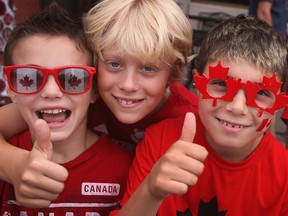 Luke Maksoud, 8, left, Cameron Skinner, 9, and Thomas O'Brien, 9, celebrate Canada Day while watching the Windsor Canada Day Parade, Tuesday, July 1, 2014.  (DAX MELMER/The Windsor Star)