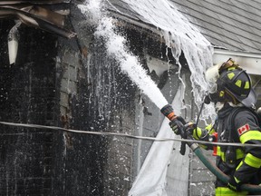 Windsor firefighterw work to extinguish a house fire on Cataraqui Street on Saturday, July 12, 2014. (DAX MELMER/The Windsor Star)