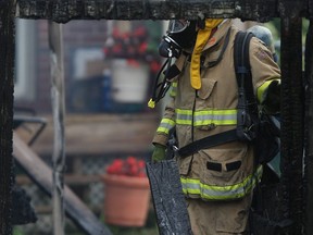 A Windsor fire fighter checks for hot spots following a fire at 3779 Riberdy Rd. in Windsor on Friday, July 25, 2014. (DAX MELMER/The Windsor Star)