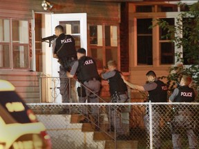 Windsor Police ESU members enter a home on Moy Avenue near Wyandotte after a stabbing. (JASON KRYK/The Windsor Star)