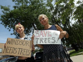 Rosalie Edwards and Elaine Weeks (right) hold up save our tree signs in an effort to raise awareness of the city's plan to remove all the existing trees on Wyandotte in Walkerville during upcoming street scaping in Windsor on Monday, June 30, 2014.        (Tyler Brownbridge/The Windsor Star)