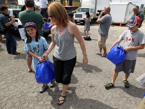 Abby, Mary-Ellen and Owen Kavanaugh transport water jugs in Windsor on Thursday, July 24, 2014. A group of Canadians delivered containers of water to a water station in Detroit as a show of support for those who have had their water shut off.                (Tyler Brownbridge/The Windsor Star)