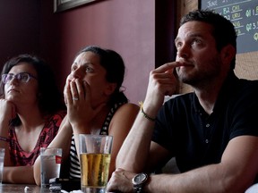 Soccer fans, from left to right, Jenn Kakoz, Riva Aaocs and Jeff Aaocs  intently watch during overtime action inside The Manchester Pub, Sunday, July 13, 2014. Germany beat Argentina 1-0 in the FIFA World Cup finals. (RICK DAWES/The Windsor Star)