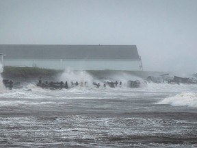 Waves crash against rock embankments that protect the Escuminac road against erosion during Tropical storm Arthur in Escuminac, N.B. on Saturday, July 5, 2014. THE CANADIAN PRESS/Diane Doiron