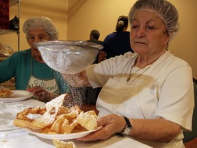 St. Angela Church Crostoli Club members Silvana Minaudo, left, and Adelide LaPosta add icing sugar to fresh crostoli, the popular Italian pastry made of flour and eggs at St. Angela Church Hall Thursday August 7, 2014. (NICK BRANCACCIO/The Windsor Star)