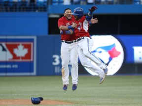 Jose Bautista #19 of the Toronto Blue Jays is congratulated on his game-winning hit by Melky Cabrera #53 in the ninteenth inning during MLB game action against the Detroit Tigers on August 10, 2014 at Rogers Centre in Toronto. (Tom Szczerbowski/Getty Images)