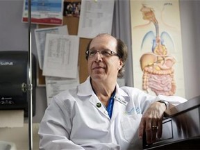 Dr. Lawrence Cohen, a specialist in gastroenterology, poses near a poster depicting the human gastrointestinal tract at the Sunnybrook Health Sciences Centre in Toronto on Thursday, August 7, 2014. THE CANADIAN PRESS/Darren Calabrese