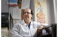 Dr. Lawrence Cohen, a specialist in gastroenterology, poses near a poster depicting the human gastrointestinal tract at the Sunnybrook Health Sciences Centre in Toronto on Thursday, August 7, 2014. THE CANADIAN PRESS/Darren Calabrese