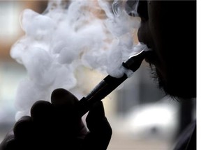 In this April 23, 2014, file photo, an electronic cigarette is demonstrated in Chicago. E-cigarettes may or may not be healthier, but they can save smokers some money. (Postmedia News files)