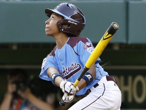 Philadelphia's Mo'ne Davis drives in a run with a single to right field off Pearland  pitcher Clayton Broeder during the first inning of a baseball game at the Little League World Series tournament in South Williamsport, Pa., Sunday, Aug. 17, 2014. (AP Photo/Gene J. Puskar) ORG XMIT: PAGP130
