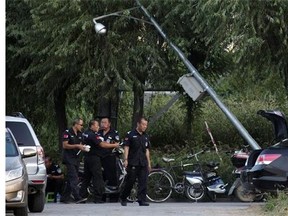 In this photo taken Sunday, Aug. 24, 2014, security guards eat their meal as they watch the home of Li Xianting, a film critic and founder of the Li Xianting Film Fund, the organizer of the Beijing Independent Film Festival in Beijing, China. China is avidly wooing filmmakers to create more documentaries to replace popular dating, reality and game shows. But it is also stifling material with any whiff of challenging the Communist Party line. (AP Photo/Ng Han Guan)