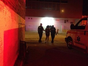 Deanna Anne Gamblin is lead away in handcuffs after she drove her car into two men in a parking lot west of Pelissier Street in Windsor on Aug. 3, 2014.  One of the men sustained severe brain injuries and died four days later.