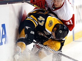 Boston's Torey Krug, left, is checked by Detroit's Luke Glendening during the first period of Game 2 in Boston. (AP Photo/Winslow Townson)