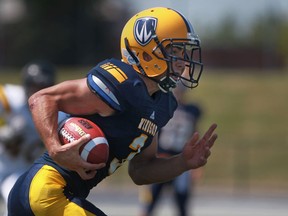 University of Windsor's  Beau Lumley carries the football against the Waterloo Warriors at Alumni Field. (DAX MELMER/The Windsor Star)