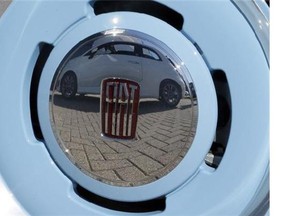 A Fiat 500 GQ cabrio edition is reflected in the hubcaps of a Fiat 500 1957 Edition in Auburn Hills, Mich., May 6, 2014. THE CANADIAN PRESS/AP, Carlos Osorio