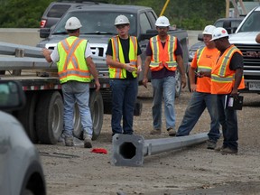 Investigators at the scene where a worker was injured unloading utility poles for the Herb Gray Parkway project near the corner of Ojibway Parkway and E.C. Row Thursday August 21, 2014. Windsor Police and construction investigators were at the scene and the Ministry of Labour was called. The worker was taken by ambulance to hospital.  (NICK BRANCACCIO/The Windsor Star)