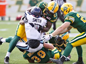 Toronto's Branden Smith, centre, is tackled by U of W grad Mike Dubuisson, top, Corbin Sharun, below, Nathan Kanya, back, and Mike Miller during second-half action in Edmonton Saturday. (THE CANADIAN PRESS/Jason Franson)